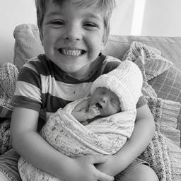 Newborn in Brother's Arms